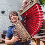 Alex Meixner speelt accordeon buiten op een zonnige dag