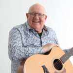 Henk Wijngaard met akoestische gitaar, portretfoto