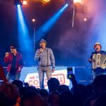 The Dutch Boys op het podium van C'est la Vie in Emmen: twee zangers met hoed en een accordeonist